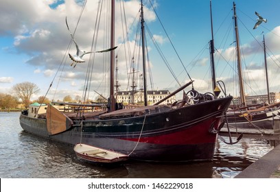 View of Amsterdam - old wooden sail ships moored in the harbor of Oosterdok near the Maritime Museum. Dutch quay with vintage sailing vessels. - Powered by Shutterstock