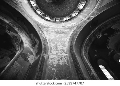 View of an ancient, ornate dome with intricate patterns, peeling paint on walls, and curved arches, captured in dramatic black and white. - Powered by Shutterstock