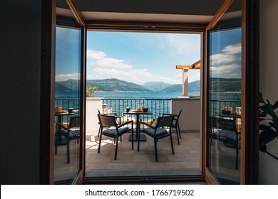 View From The Apartment At Sea. Balcony With Garden Furniture And Breakfast On The Table. Croissants And Freshly Squeezed Orange Juice.