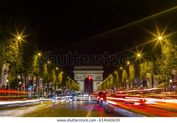 View\
of Arc de Triomphe and the avenue Champs-Elysees by night. Famous\
touristic places and romantic travel destinations in Europe. Urban\
landscape with night traffic. Long exposure.\
Toned