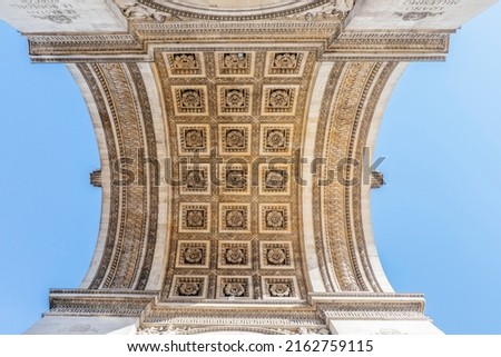 View of the Arc de Triomphe from below in Paris at Chaps Elysees, Paris, France. Architecture and monuments of Paris. Paris postcard