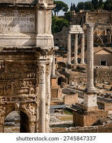 View of the Arch of Septimius Severus and classical columns in the Roman Forum, Rome, showcasing ancient ruins and historic architecture.