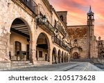 view of the arches and church from the main square of Trujillo, Extremadura, Spain - sunset sky
