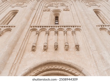 View of the architectural element of the blind arcade on the facade of ancient white stone Church of the Intercession on the Nerl. Temple in the Vladimir region of Russia, built in the 12th century.