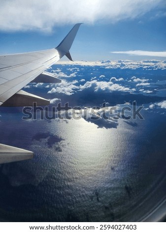 View from the areoplane window of the wing over clouds.