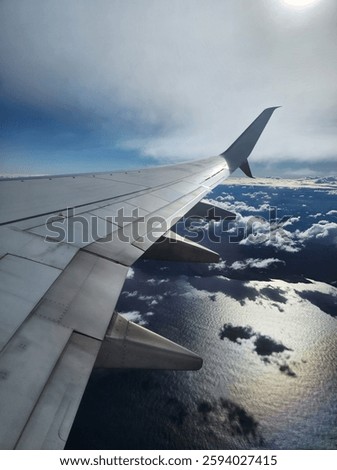 View from the areoplane window of the wing over clouds.