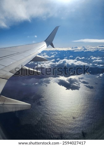 View from the areoplane window of the wing over clouds.