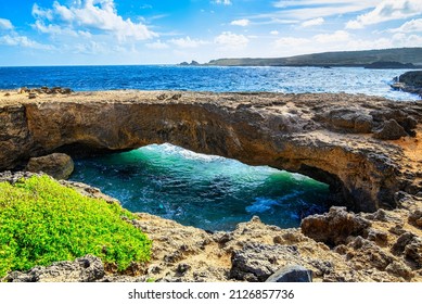 A view of the Aruba Natural Bridge in the Caribbean under blue skies looking out to sea - Shutterstock ID 2126857736