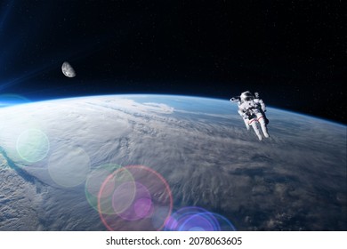 View of an astronaut in extravehicular activity with the Earth and the Moon in the background. Photo montage. Elements of this image furnished by NASA. - Powered by Shutterstock