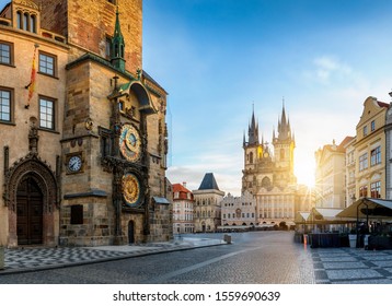 View to the astronomical clock and the old town square of Prague with Tyn Church in the background during sunrise time without people. Czech Republic
