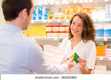 View Of An Attractive Pharmacist Taking Healt Insurance Card