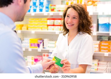 View Of An Attractive Pharmacist Taking Healt Insurance Card