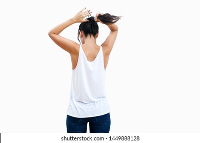 View Of Attractive Young Woman's Back As She Puts Her Hair Up In A Pony Tail