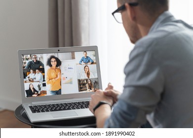 View from back above shoulder on the laptop with diverse employees, coworkers on the screen, video call, online meeting. App for video conference with many people together