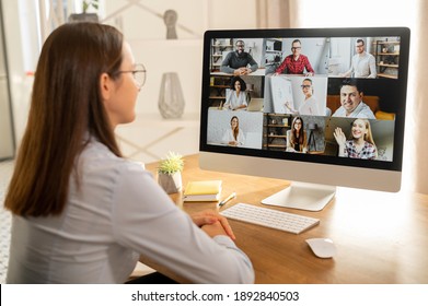 View From Back Above Shoulder On The Laptop With Diverse Employees, Coworkers On The Screen, Video Call, Online Meeting. App For Video Conference With Many People Together