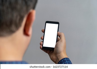 View from the back of a man head looking at a smartphone with blank screen