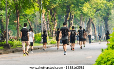view of back of people run and walk at pedestrian garden park