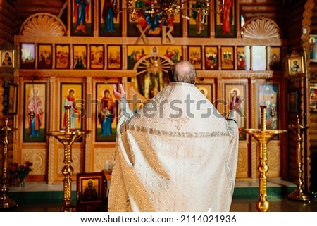 view from the back. priest at the iconostasis during the divine service. traditional Christian and church rituals.