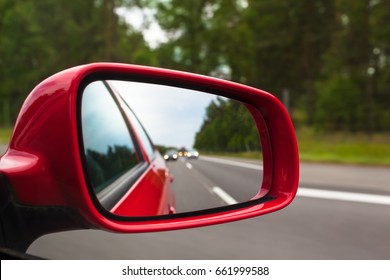 View Back To Road Through Red Side Mirror At Car/Highway Rear View