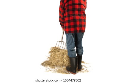 view of the back of an unidentified a farmer in a red plaid shirt with a pitch fork stuck into a bale of straw isolated on white