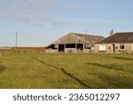View of Barn and Farm Buildings in Open Field on Sunny Day 