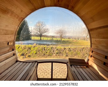 View from a barrel sauna into the beautiful nature with meadows, trees and mountains