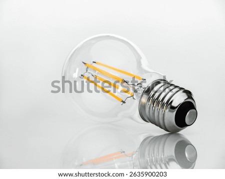 View from the base of the socket on a Filament type LED lamp isolated on a white background with reflection.
