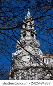 View of the BBVA building behind the trees on Avenida dos Aliados in O Porto on a blue sky day