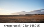 View of beautiful countryside at sunset. Beautiful autumn landscape in the hilly. Grassy field and hills. Rural landscapes.