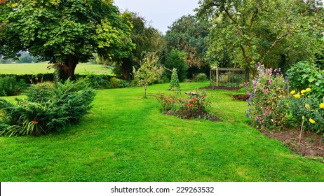 View Of A Beautiful Domestic Garden In Summer With Flower Beds And A Mowed Grass Garden Lawn - Gardening Themed Image