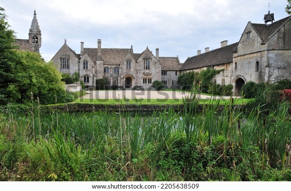View of a beautiful old mansion house and\
grounds on a street in an English\
village