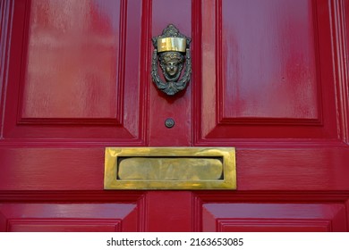 View Of A Beautiful Old Red Wooden Front Door With A Letter Box And Brass Knocker