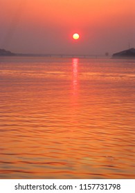 A View Of The Beautiful Sunset That Reflects And Scaters All Over The Sky And On The Mighty River Of Brahmaputra And In The Background Is Seen The Saraighat Bridge.                  