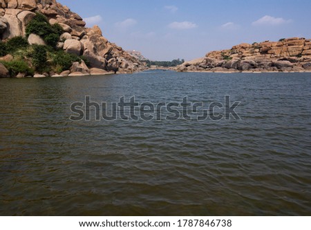 View of the beautiful Tungabhadra river from ground level converging in horizon at Hampi, Karnataka, India. Selective Focus