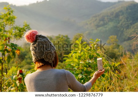 View from behind beautiful asian tourist girl looking to scenic landscape view Mist wave around mountain in morning