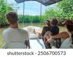 View from behind of a Family on a wildlife estuary boat tour in Costa Rica. Exploring the Tamarindo estuary and river area looking for wildlife and the mangrove forests. Costa Rican Travel photo