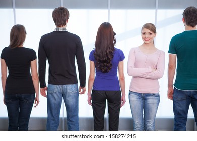 View From Behind Of Group Of People. One Girl Facing A Camera 