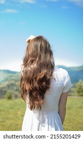 View From Behind Of Long Brunette Hair Of Young Woman Outside.