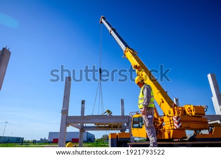 Large crane rising behind a metal roof structure