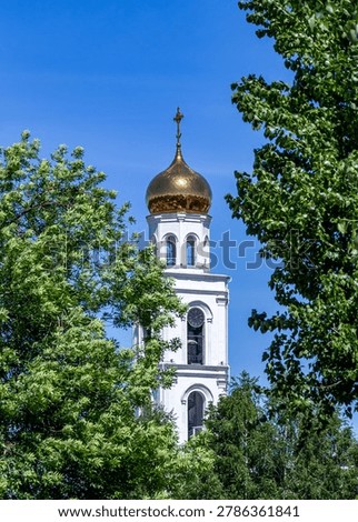 View of the bell tower of the Iversky Monastery in Samara against a blue sky in summer