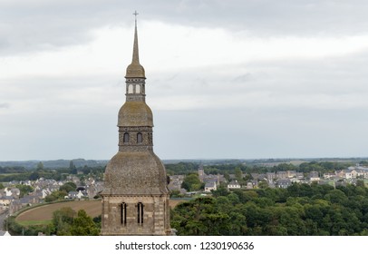 View of the bell tower of Saint Sauveur basilica, with a blue sky, in the city of Dinan, Brittany, France.
