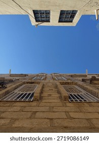 View from below of 2 adjacent apartment buildings during the day in Yemen