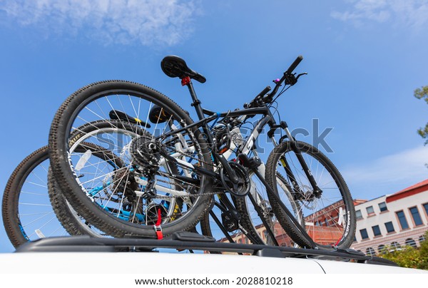 View from below of the bike rack on top of the car\
with bicycles. Street view in Victoria BC, Canada. July 23,2021.\
Travel photo, selective\
focus