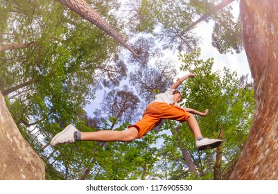 View From Below Of Boy Jump On The Big Rock