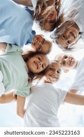 View from below of happy kids that are standing together and looking down. - Shutterstock ID 2345223163