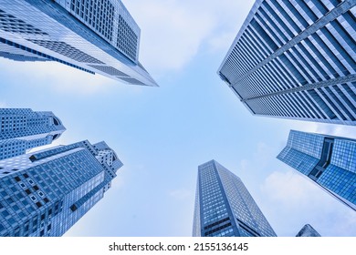 view from below of highrise building and skyscrapers in central business district with blue sky background
