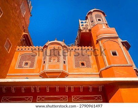 A view from below of the iconic pink and orange facade of the Hawa Mahal (Palace of the Winds) in Jaipur, India
