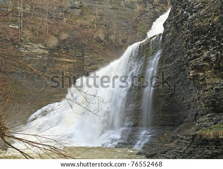 A view from below of Lucifer Falls falling in a spring torrent into Treman Gorge near Ithaca, NY