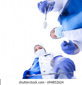 View from below of masked doctors looking at patient before surgery.