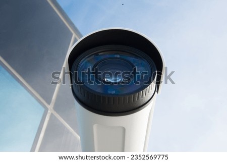 A view from below a security camera, capturing the clear lens